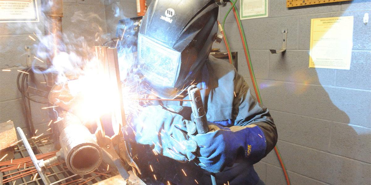 协会的 welding student with torch